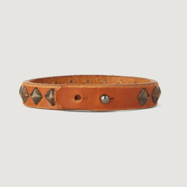 C06: Small pyramid studs line up on a thin cuff in Tan leather