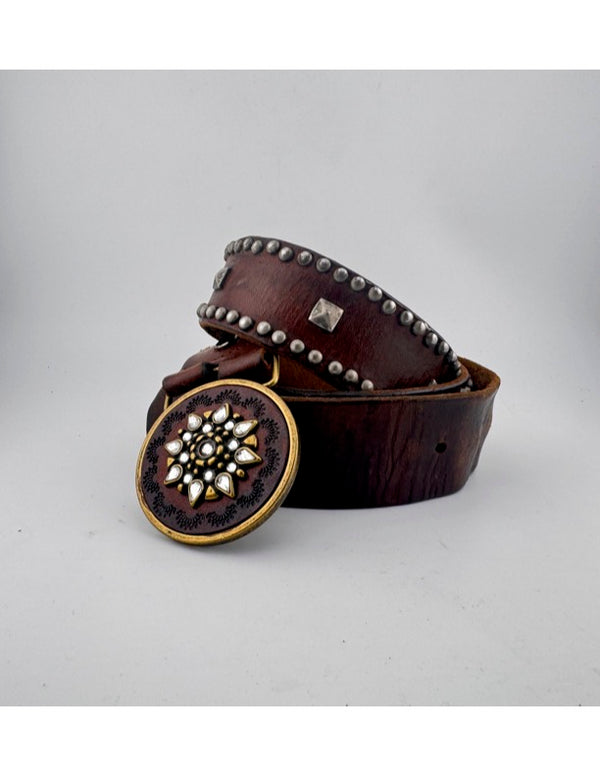 V11: Vintage belt on warm brown leather with ornate medallion buckle